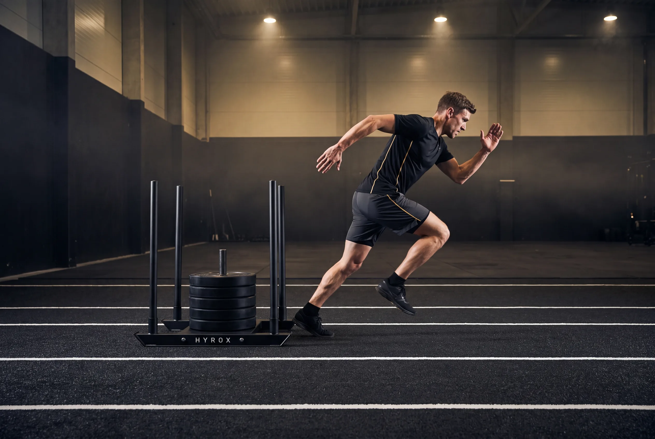 Athlete accelerating into a run straight off a HYROX sled push during training